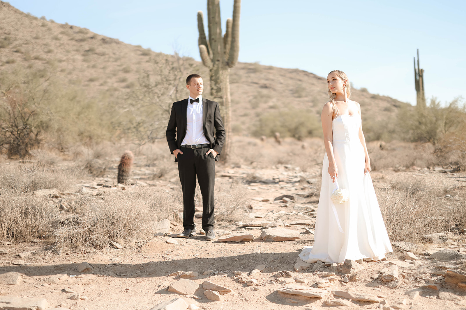 A couple eloping in the Sonoran Desert, one of the most scenic Arizona elopement locations, surrounded by towering saguaro cacti and rocky terrain.
