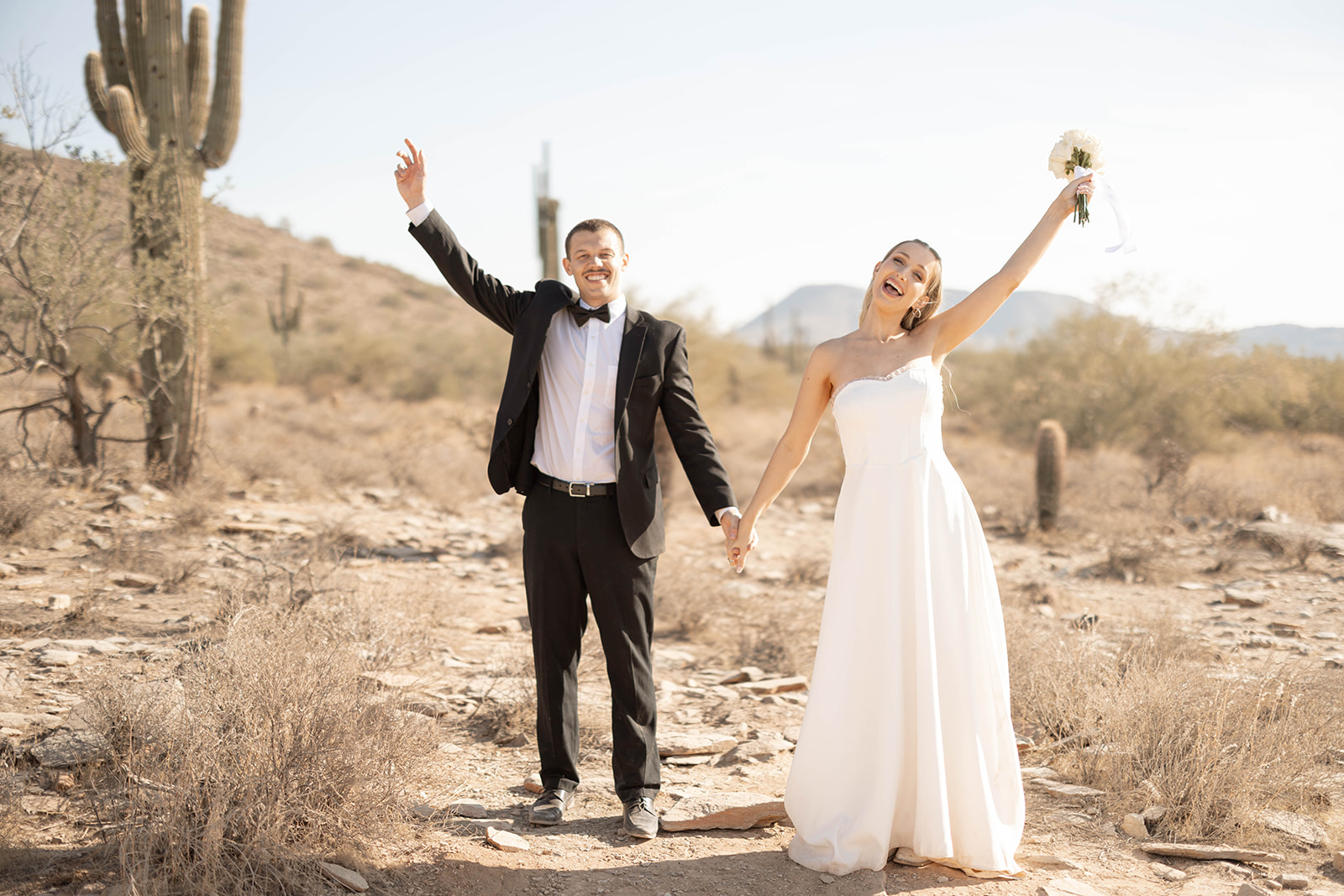 A joyful moment captured at one of the most unique Arizona elopement locations, as the newlyweds raise their arms in celebration beneath the sun.