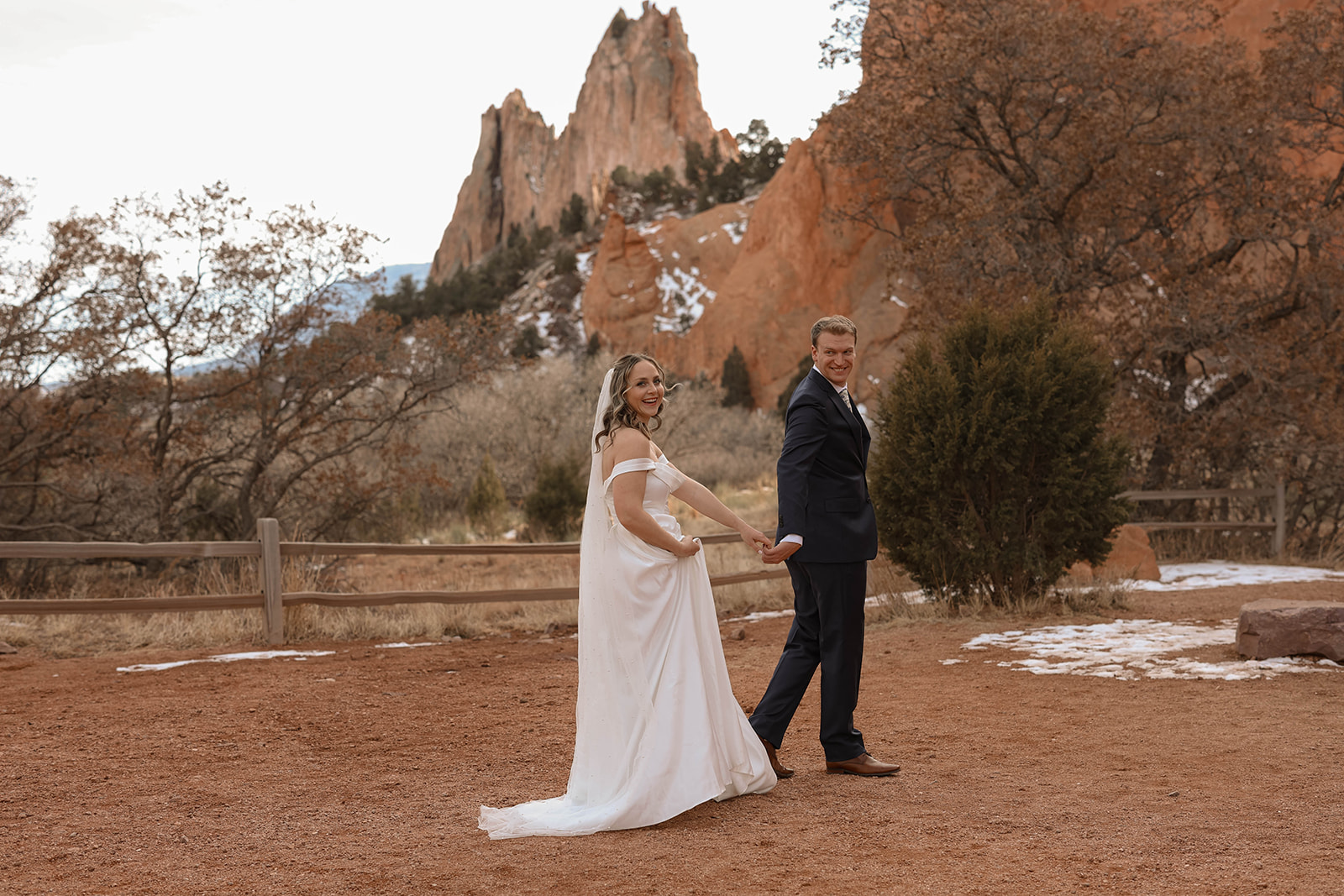 Couple shares a romantic kiss against dramatic sandstone cliffs at Garden of the Gods — capturing the best time to elope in Colorado with its stunning natural backdrops.