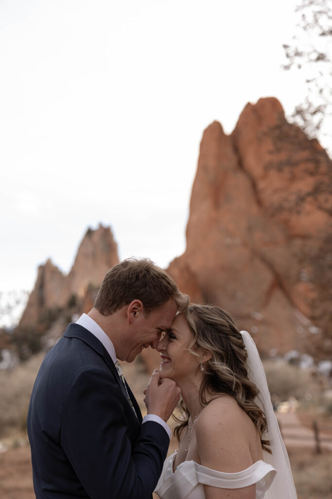 A couple shares a quiet moment, touching foreheads while eloping at one of the stunning Colorado elopement locations, Garden of the Gods.