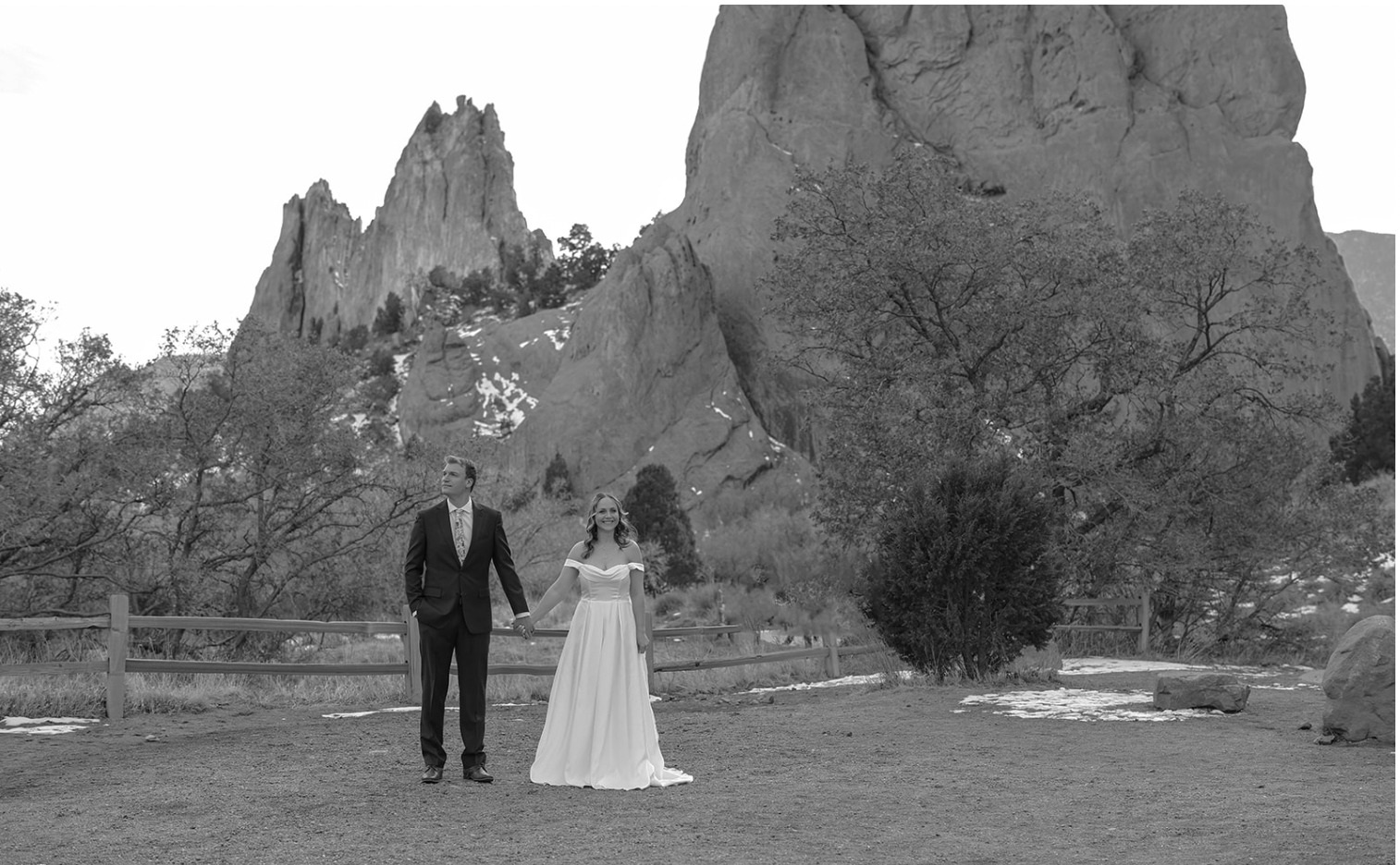 In black and white, a couple holds hands in front of the towering red rock formations—an iconic backdrop among Colorado elopement locations.