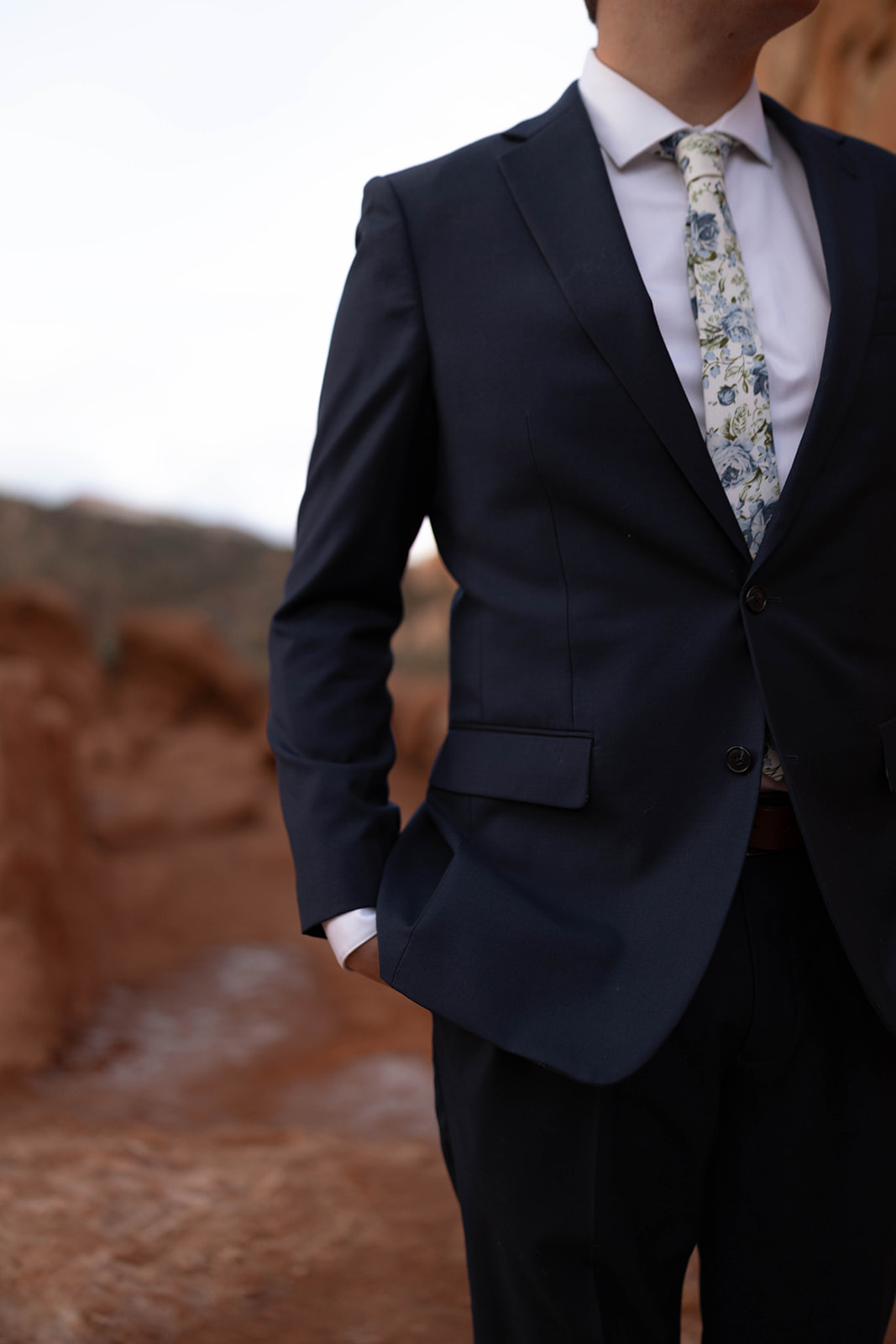 Close-up of a groom’s navy suit with a floral tie, perfect attire for celebrating the best time to elope in Colorado’s iconic landscapes.