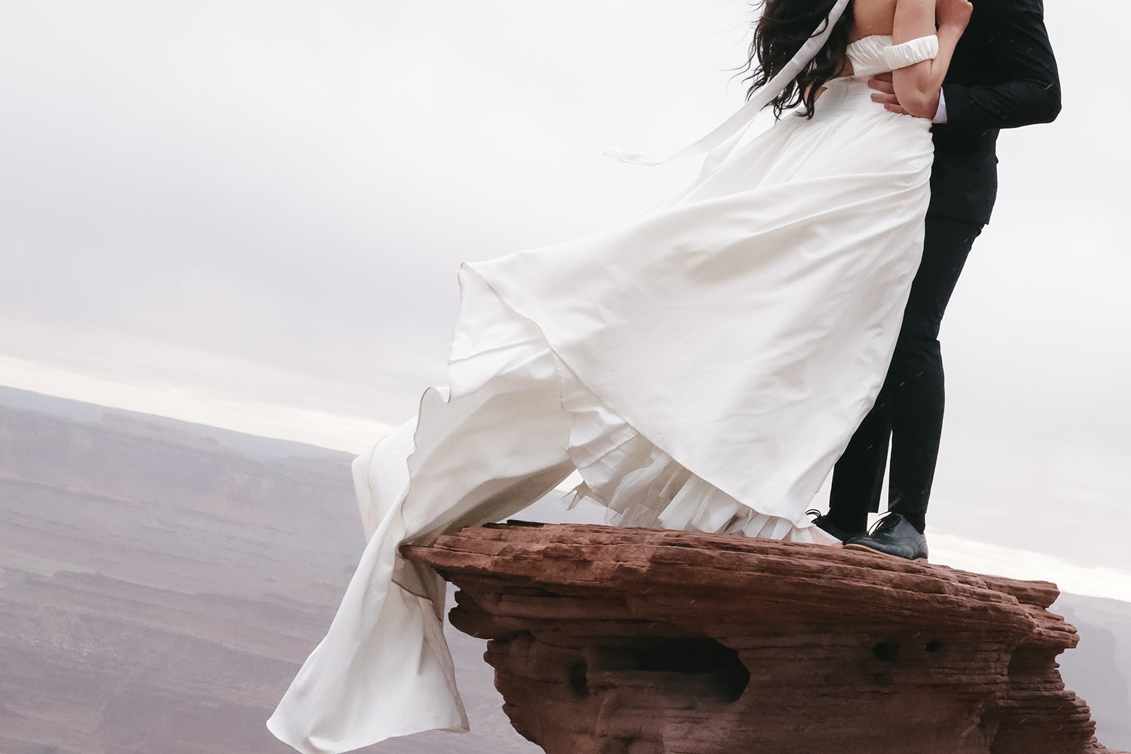 Detail shot of a flowing elopement outfit against the dramatic cliffs of the desert.