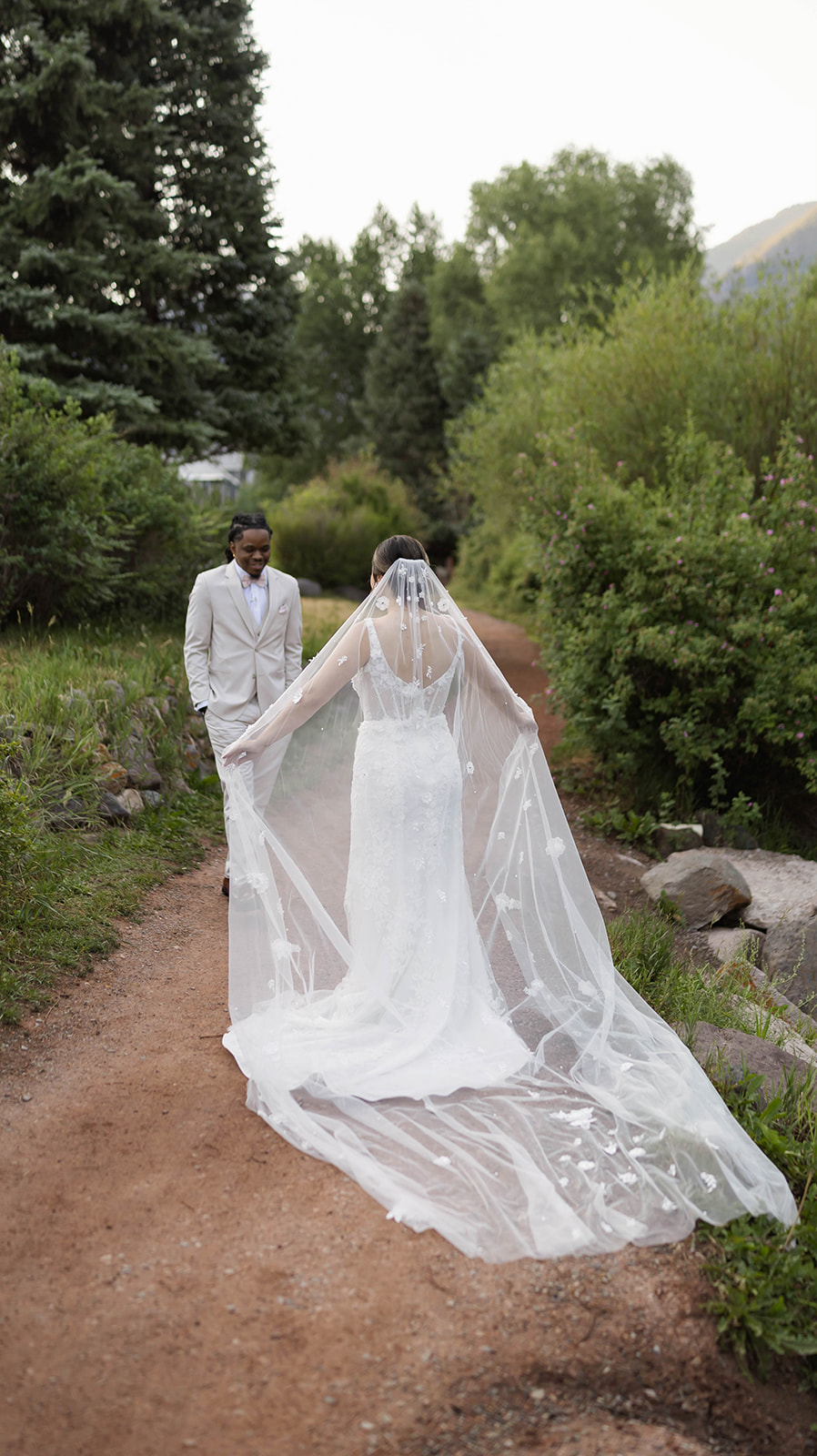 Bride and groom sharing a private first look on a forest path, the flowing veil and scenic backdrop offering beautiful elopement ideas for nature-loving couples.