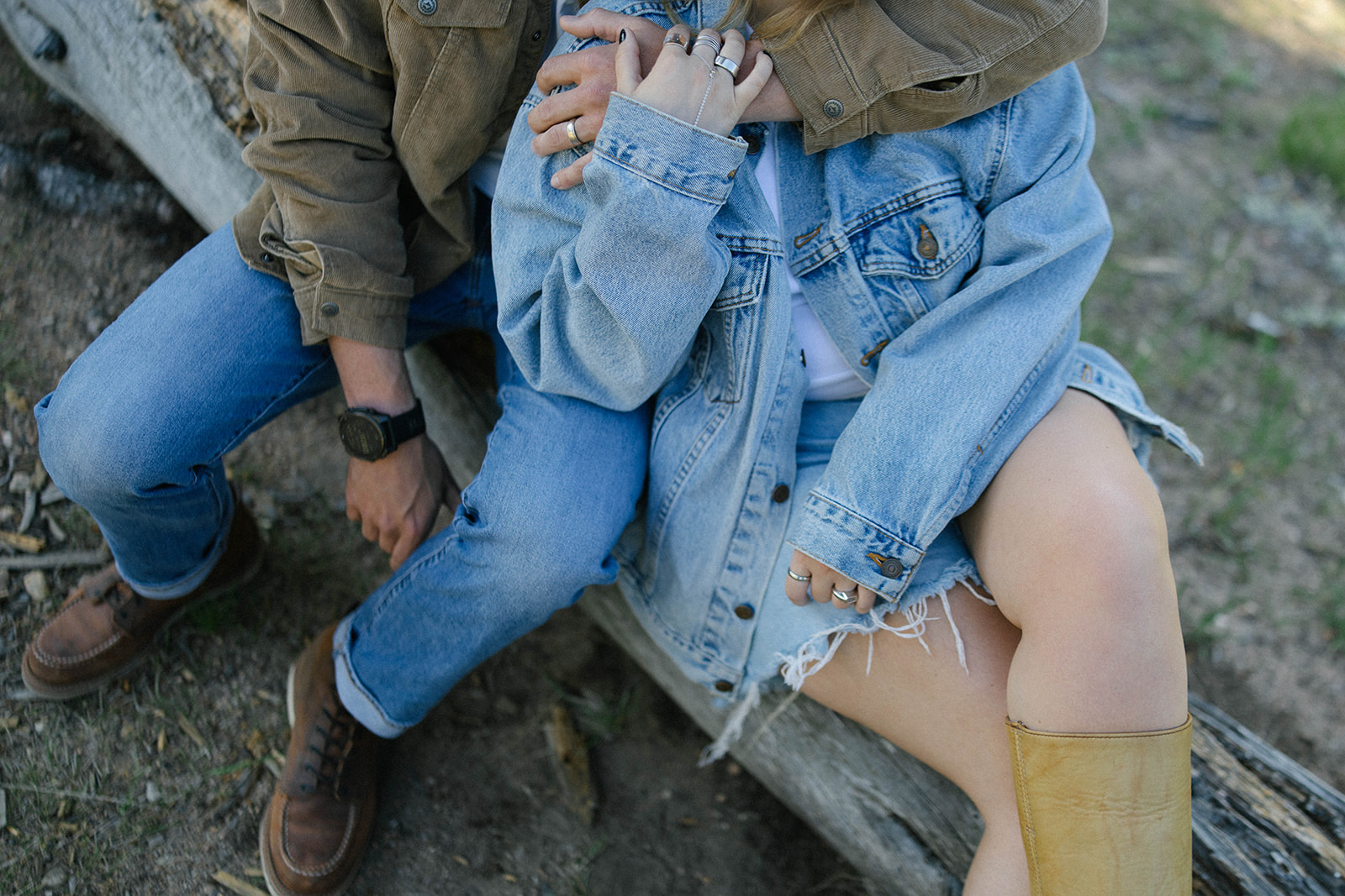 A close-up of intertwined hands and denim layers, showing cozy textures and details from a casual outdoor session.