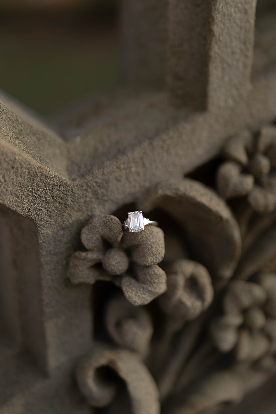 Close-up detail of an engagement ring resting on ornate stonework during a central park engagement session.
