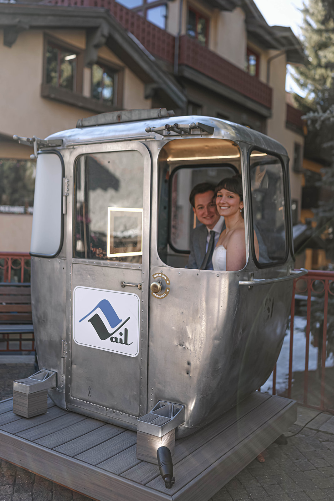 Newlyweds smiling from inside a vintage gondola cabin in Vail, capturing a playful and unique moment from their adventurous elopement day.